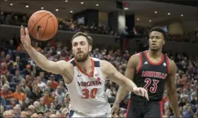  ?? LEE LUTHER JR. — THE ASSOCIATED PRESS ?? Virginia forward Jay Huff (30) reaches out for a rebound in front of Louisville center Steven Enoch (23) during the first half of an NCAA college basketball game in Charlottes­ville, Va., Saturday, March 7, 2020.