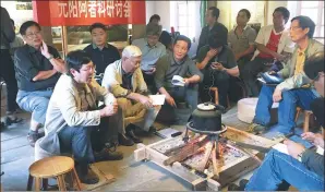  ?? FU ZHENGHUI / FOR CHINA DAILY ?? Zhu Liangwen (fifth from left) discusses the Azheke renovation project at the village in Yuanyang county, Yunnan province, with local officials and village leaders.