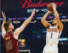  ?? Tony Dejak / Associated Press ?? The Suns’ Devin Booker shoots over the Cavaliers’ Dean Wade in the first half. Booker had 35 points to lead a 14th straight win.