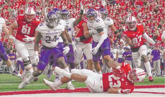  ??  ?? Wisconsin’s Jonathan Taylor scores on a seven- yard run in the first half Saturday against Northweste­rn. He added an 11- yard touchdown run in the second half. | MORRY GASH/ AP