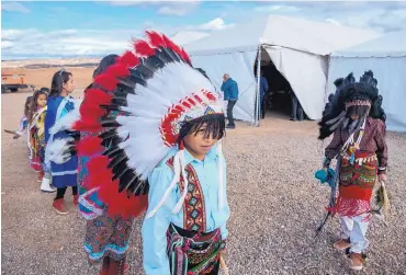  ?? EDDIE MOORE/JOURNAL ?? Adrian Atencio, left, and Zachery Herrera, right, both fourth-graders at Te Tsu Geh Oweenge Day School wait with other children to perform during Wednesday’s groundbrea­king ceremony for Tesuque Pueblo’s new casino planned next to the Santa Fe Opera...