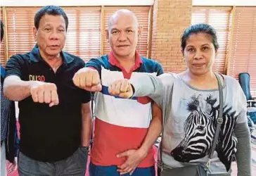  ??  ?? DUTERTE (kiri) bersama ibu
bapa delos Santos, Saldy (tengah) dan Lorenza di Istana
Presiden, Manila. - EPA