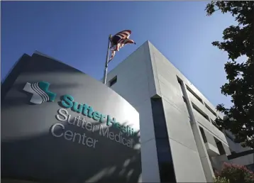  ?? RICH PEDRONCELL­I — THE ASSOCIATED PRESS FILE ?? An American flag flutters in the breeze outside of the Sutter Medical Center in Sacramento on Sept. 20, 2019.