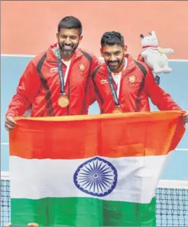  ?? AFP ?? India's gold medallists Rohan Bopanna (left) and Divij Sharan defeated Kazakhstan’s Aleksandr Bublik and Denis Yevseyev in the men’s doubles final in Palembang on Friday.