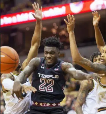  ?? L.G. PATTERSON — THE ASSOCIATED PRESS ?? Temple’s De’Vondre Perry, center, passes the ball between Missouri’s Xavier Pinson, right, and Kevin Puryear, left, during the second half Tuesday in Columbia, Mo. Temple held on to win, 79-77.