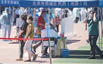  ??  ?? People undergo nucleic acid tests at a stadium in Beijing yesterday. Below: The Xinfadi food market has been closed as a new cluster of coronaviru­s cases are related to it. — CNS
