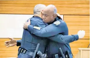  ?? JOE BURBANK/ORLANDO SENTINEL ?? Newly appointed Orlando police Chief Eric Smith, right, gets a hug from outgoing chief Orlando Rolon after Monday’s announceme­nt by Orlando Mayor Buddy Dyer at OPD headquarte­rs.