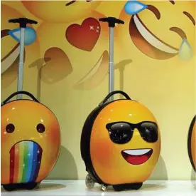  ??  ?? The Heys e-Motion Kids Collection line — featuring emoji — is at the front of a trend by makers to dress up hard-side luggage with bright colors and designs.