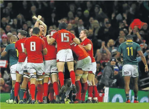  ?? Picture: AFP ?? Wales fullback Leigh Halfpenny jumps onto his teammates as they celebrate after winning the test match against South Africa at the Principali­ty Stadium, south Wales, yesterday.