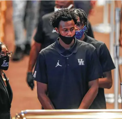  ?? Godofredo A. Vásquez / Staff photograph­er ?? University of Houston men’s basketball players and staff members pass the casket of George Floyd during a public visitation Monday. The Cougars’ campus is located in the Third Ward, just a few blocks from where Floyd grew up.