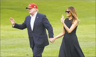  ?? Olivier Douliery / TNS ?? President Donald Trump and first lady Melania Trump walk on the South Lawn of the White House after arriving on Marine One in Washington on Friday.
