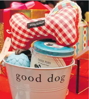  ??  ?? Gifts displayed in a doggie gift bucket include a Harry Barker doggie bone, a rubber chew toy and doggie cheese puffs.