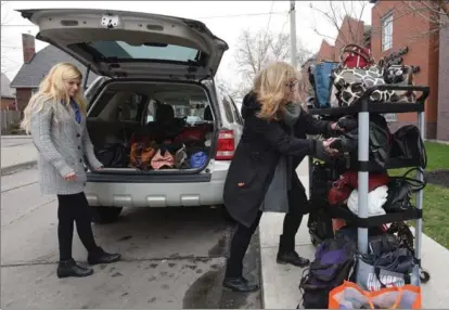  ?? CATHIE COWARD, THE HAMILTON SPECTATOR ?? Denise Davy, and helper load some of the more than 60 handbags filled with women’s hygiene products onto a cart outside Mary’s Place Tuesday afternoon. Davy has collected these products for women living on the streets.