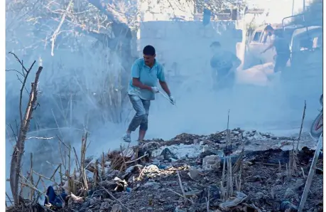  ??  ?? Dousing the flames: Syrians using dirt to put out a fire at the scene of a reported air strike in the district of Jisr al-Shughur, in the Idlib province.