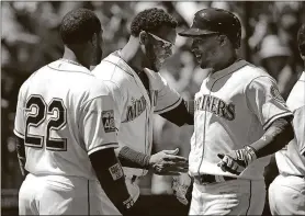  ?? ASSOCIATED PRESS TED S. WARREN / THE ?? The Mariners’ Leonys Martin, right, is greeted at the dugout by Robinson Cano, left, and Nelson Cruz, center, after Martin hit a solo home run Sunday in Seattle.