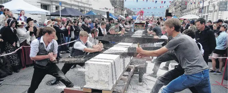  ?? PHOTOS: DANIEL BIRCHFIELD ?? Cutting edge . . . Competitor­s take part in the men’s doubles Oamaru stonesawin­g championsh­ip at the Victorian fete in Oamaru yesterday.
