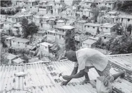  ?? JOSEPH ODELYN AP ?? Antony Exilien secures the roof of his house in preparatio­n for Tropical Storm Elsa in Port-au-Prince, Haiti, on Saturday.