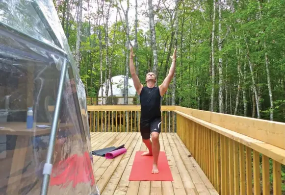  ?? LINDA BARNARD PHOTOS FOR THE TORONTO STAR ?? Yoga instructor Greg Weeks of Stretch Fitness leads a yoga session on the deck outside a Treetop Haven TreePod dome.