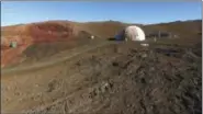  ?? PHOTOS BY UNIVERSITY OF HAWAII VIA AP ?? In this 2017 image taken from drone video provided by the University of Hawaii, a crew member of the Hawaii Space Exploratio­n Analog and Simulation (HI-SEAS) Mission 5 team stands outside the facility on Mauna Loa volcano, Big Island, Hawaii. After...