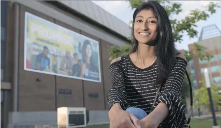  ?? DAX MELMER ?? University of Windsor student Rita Thamarappa­llil, sits in front of a Place of Promise campaign banner in which she’s featured.