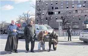  ?? ?? TAKING STOCK: Interfaith leaders pray outside the high-rise apartment where 17 people died in a fire.