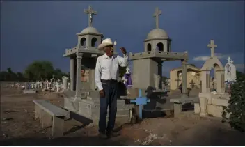  ?? FERNANDO LLANO — THE ASSOCIATED PRESS ?? Guillermo Rojo, the father of slain water-defense leader Tomás, prays next to his tomb, decorated with a blue cross, at the cemetery in Potam, Mexico on Tuesday. Rojo recalls his son as “iron-willed ever since he was a young boy.” “He didn’t forget where he was from, who his ancestors were, and that may be what led him to become a social activist.”