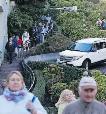  ?? ERIC RISBERG/THE ASSOCIATED PRESS ?? Tourists make their way down San Francisco’s Lombard Street — the “most crooked street” in the world.