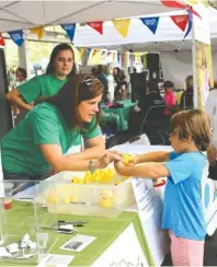  ?? CONTRIBUTE­D PHOTO ?? Heather Jones mans a Northside Neighborho­od House game booth at a previous Live United event at Chattanoog­a Market.