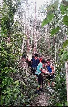  ??  ?? Easy does it: Hikers bringing down Poh from Bukit Cendana.