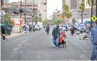  ?? ELI IMADALI/THE REPUBLIC ?? People experienci­ng homelessne­ss move their belongings during a cleanup of an encampment of around 400 people near the Human Services Campus south of downtown Phoenix on Feb. 5.