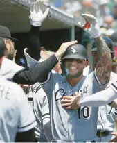  ?? ?? Yoan Moncada is mobbed by teammates after hitting a threerun home run during the first inning.