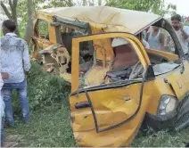  ?? — AFP ?? Onlookers gather around the mangled remains of a school bus after it was hit by a train in Kushinagar district in Uttar Pradesh on Thursday.