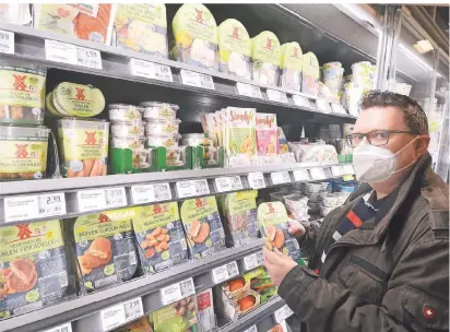  ?? FOTO: WOI ?? Auf den Versandhan­del ist Thomas Schwarz nicht mehr angewiesen, wenn er vegane Produkte sucht. Die findet er in großer Auswahl in gut sortierten Supermärkt­en wie dem Rewe-Markt von Marco Pfeffel, in dem er selbst einkauft.