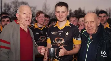  ??  ?? David Doran receives the Oliver J. Murray Memorial Cup from Jim Murray and Jack O’Brien.