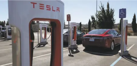  ?? Justin Sullivan / Getty Images ?? The new Tesla models would have a range that is 56% farther than current vehicles, like this one charging in Petaluma.