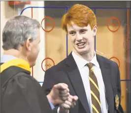  ?? Tyler Sizemore / Hearst Connecticu­t Media ?? Greenwich’s Fin Signer fist bumps teacher Steve Spolikoff before the Brunswick School 117th commenceme­nt in the Dann Gymnasium Wednesday.