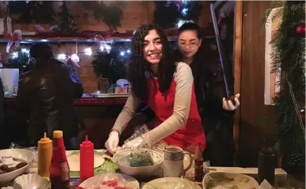  ?? (Michelle Martin/Reuters) ?? SYRIAN REFUGEES Mayar (left) and Nawar Ballish make falafel sandwiches at a Christmas market in Schillings­fuerst, Germany, late last year.