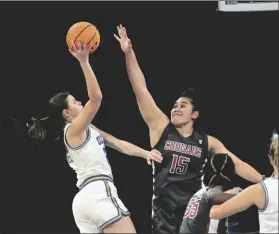  ?? DAVID BECKER/AP ?? WASHINGTON STATE CENTER BELLA MUREKATETE (55) shoots against UCLA guard Camryn Brown during the first half of an NCAA college basketball game in the finals of the Pac-12 women’s tournament on Sunday in Las Vegas.