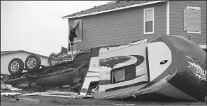  ?? AP/ERIC GAY ?? A destroyed camper trailer sits in front of Steve Hagdorn’s storm-damaged home Monday in Rockport, Texas, as he covers shattered windows.