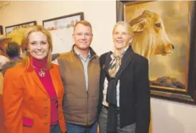  ??  ?? Ces Grant, right, stands with Best in Show sponsors Kathy and Brad Coors in front of the Best in Show painting, Teresa Elliott’s “Brahman Cow.”