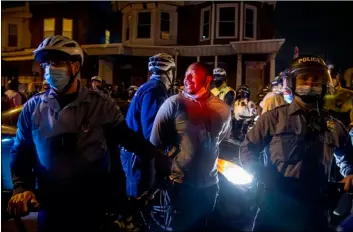  ?? Tom Gralish/The Philadelph­ia Inquirer via AP ?? A person is handcuffed and detained by police at 55th and Pine Street, on Wednesday in Philadelph­ia, after the citywide curfew had passed, two days after Walter Wallace Jr. was killed by police officers.