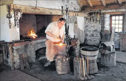  ?? PHOTO SUBMITTED BY PARKS CANADA ?? Graham Tourneur works in the forge at the Fortress of Louisbourg National Historic Site in this Parks Canada photo. Visitation at the fortress was up by 39 per cent year-to-date as of the end of July over the same period last year. Admission at...