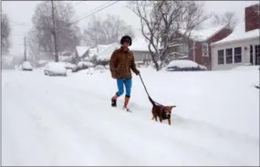  ?? /CHUCK BURTON—ASSOCIATED PRESS ?? A man jogs with his dog down a snow-covered street in Greensboro, N.C., Sunday, Dec. 9, 2018. A massive storm brought snow, sleet, and freezing rain across a wide swath of the South on Sunday - causing dangerousl­y icy roads, immobilizi­ng snowfalls and power losses.