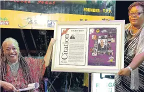  ??  ?? Beverley Lashley, national librarian (left), presenting Jean ‘Binta’ Breeze with Citation and 2018 Lifetime Achievemen­t Award of the Jamaica Poetry Festival.