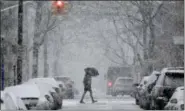  ?? SETH WENIG — THE ASSOCIATED PRESS ?? A man crosses the street through heavy snow in Hoboken, N.J., Wednesday.