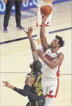  ?? Mike Ehrmann / Getty Images ?? Jimmy Butler of the Heat shoots over Markieff Morris of the Lakers in the fourth quarter. Butler had a triple-double.