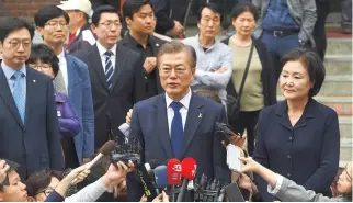  ??  ?? SOUTH KOREAN presidenti­al candidate Moon Jae-In (C) of the Democratic Party speaks to the media after casting his ballot at a polling station in Seoul on May 9. South Koreans went to the polls on May 9 to choose a new president after Park GeunHye was...