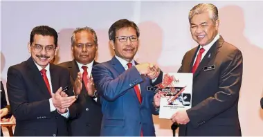  ?? — Bernama ?? Good guide: Dr Ahmad Zahid (right) handing the Recruitmen­t Profiling Manual to Home Ministry secretaryg­eneral Datuk Seri Alwi Ibrahim at a monthly KDN assembly.