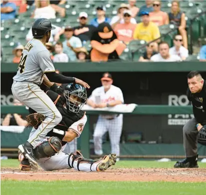  ?? TERRANCE WILLIAMS/AP ?? Pirates left fielder Greg Allen, left, is tagged out by Orioles catcher Robinson Chirinos in the seventh inning Sunday. Upon review, Allen was called safe, and soon after Orioles manager Brandon Hyde was ejected for arguing with the umpires.