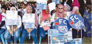  ?? Agence France-presse ?? Palang Pracharat party supporters display placards during a campaign rally in Narathiwat on Sunday.